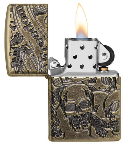 Armor® Antique Brass Skull Design Windproof Lighter with its lid open and lit