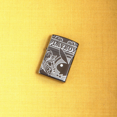 Lifestyle image of Playboy 360° Design Windproof Lighter laying on a yellow background