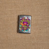 Lifestyle image of Psychedelic Lip Design Street Chrome Lighter laying on hemp fabric