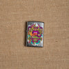 Lifestyle image of Psychedelic Lip Design Street Chrome Lighter laying on hemp fabric