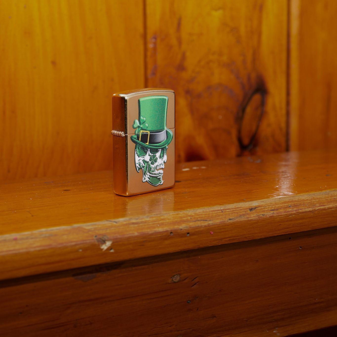 Lifestyle image of Irish Skull Design Gold Dust Windproof Lighter standing on a wooden banister
