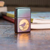 Lifestyle image of Raven Design Iridescent Windproof Lighter standing on a desk in front of books