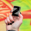 Lifestyle image of 2020 Collectible of the Year Windproof Lighter in hand with graffiti in the background