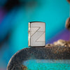 Lifestyle image of 2020 Collectible of the Year Windproof Lighter standing on a stone surface with blue graffiti in the background